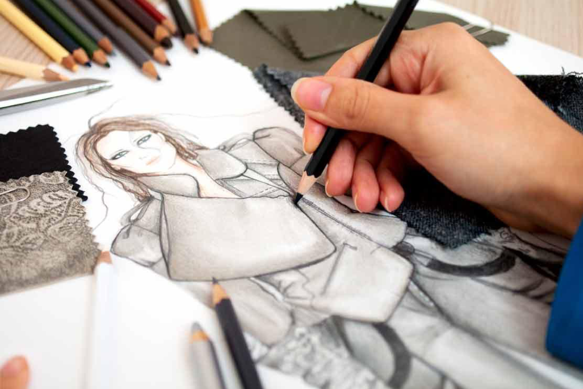 una mano che disegna un figurino di moda