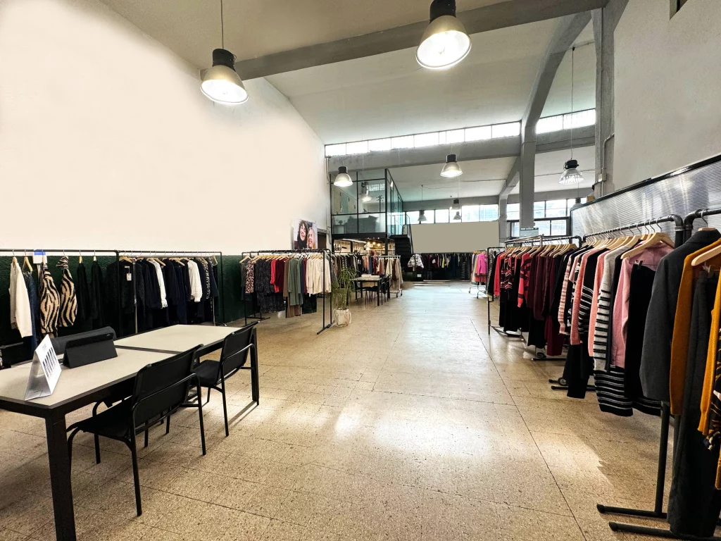 stanza con rail di abbigliamento e capi appesi showroom della badii fashion group